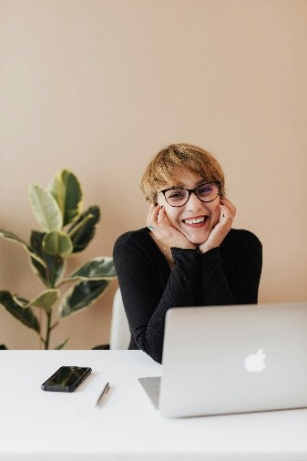 Girl smiling and a laptop on desk